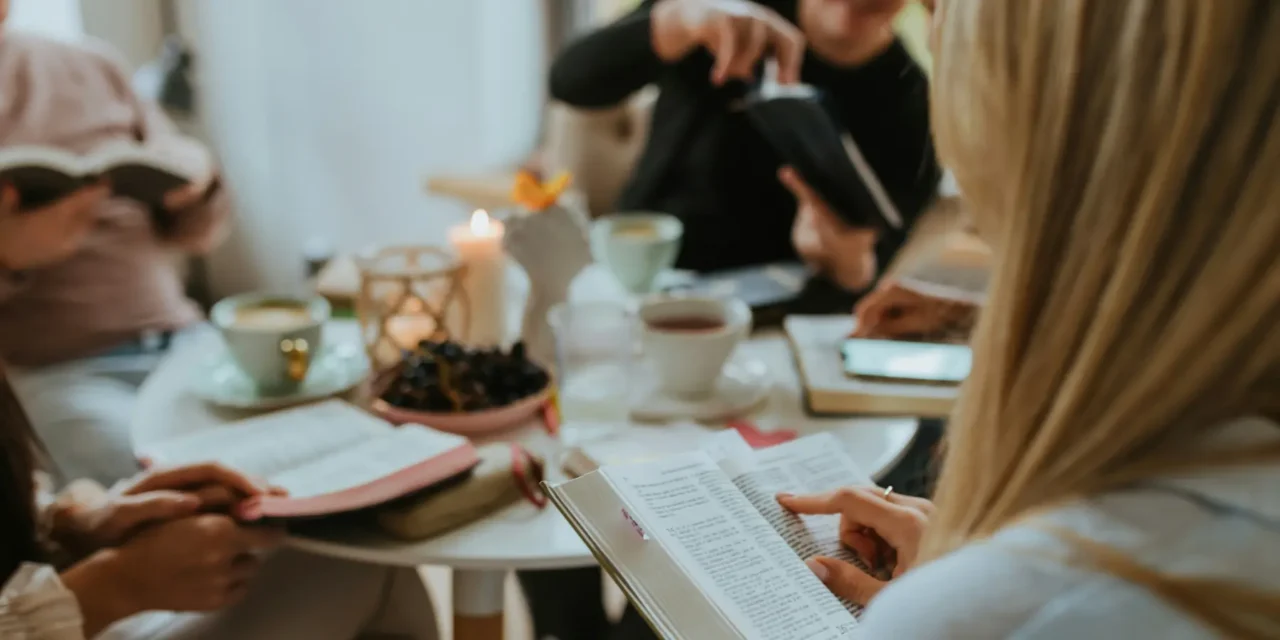 Christian devotional encouragement and prayerful reflection shown through a small group Bible study sharing Scripture, prayer, and fellowship around a table