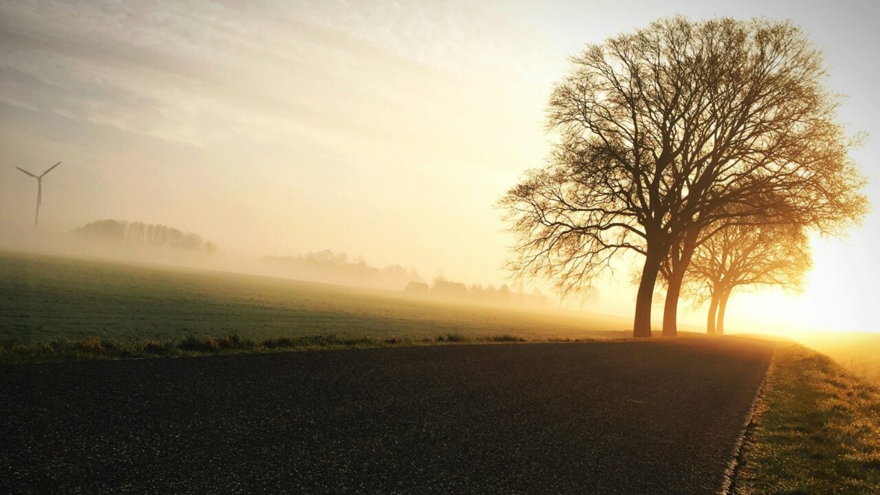 Sunrise over a quiet country road with soft morning light symbolizing hope, reflection, and a new day.